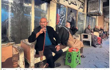  ?? — AP ?? No more the in-thing: Patrons sitting outside Hassan Ajami cafe in al-Rasheed street, that used to bustle with cultural activity, in Baghdad.