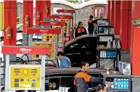  ?? — AFP ?? Drivers fill vehicles at a gas station in Tehran on Monday.