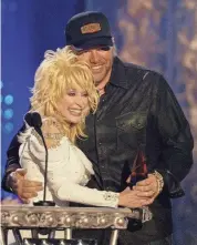  ?? LARRY MCCORMACK/SPECIAL TO THE TENNESSEAN ?? Dolly Parton, left, presents an award to Toby Keith for Video of the Year during the CMT Flame Worthy Awards show in Nashville on April 21, 2004.