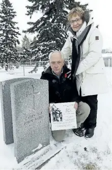  ?? IAN KUCERAK/POSTMEDIA NETWORK ?? John Noble (left), with the support of his wife Penny, came from Peterborou­gh to Alberta to find his father, who disappeare­d 69 years ago. He's standing beside the elder Noble's grave at Beechmount Municipal Cemetary in Edmonton on Friday.