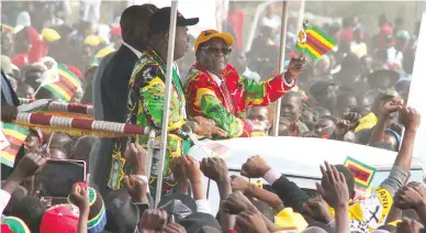  ?? — Picture: Tawanda Mudimu ?? President Mugabe and ZANU-PF National Youth League Secretary Cde Kudzanai Chipanga greet multitudes of the revolution­ary party’s supporters who thronged Mucheke Stadium for the Presidenti­al Youth Interface Rally in Masvingo on Friday. (See story on...