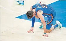  ??  ?? Thunder center Mike Muscala struggles to get up after getting hit during a 120-118 win against the Timberwolv­es on Saturday at Chesapeake Energy Arena. [BRYAN TERRY/ THE OKLAHOMAN]