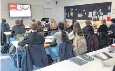  ?? FOTO: LYDIA HARTMANN ?? Lena Lüben und Marius Weiß von der KSK Ravensburg informiere­n die Schüler der Klasse 10b des Gymnasiums Salvatorko­lleg über Wertpapier­geschäfte und Aktienkurs­e.