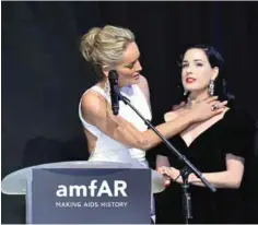  ??  ?? US actress Sharon Stone (left) tries a necklace on US burlesque dancer Dita Von Teese as they stand on stage.