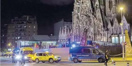  ??  ?? ► Policías vigilan la Sagrada Familia tras la alerta terrorista en la que se encuentra la ciudad.
