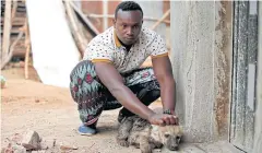  ?? REUTERS ?? Abbas Yusuf, 23, known as Hyena Man, plays with a cub in Harar, Ethiopia.