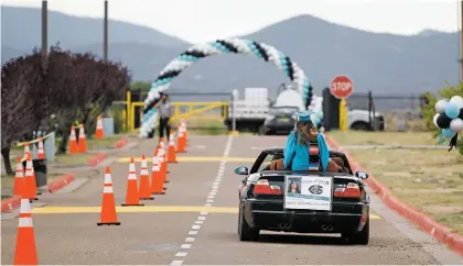  ??  ?? Abril Julieta Dominguez, 18, drives away with her family Friday after receiving her diploma.