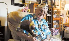  ?? ERIC RISBERG/AP ?? Mickey Ganitch is a 101-year-old survivor of the attack on Pearl Harbor. Above, Ganitch holds a football statue he was given at his home Nov. 20 in San Leandro, California.