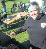  ?? PHOTOS: HAMISH MACLEAN ?? Manning the grill . . . Colin Robson, of Dunedin, gets some sausages going at the Kurow Harness Racing Club Raceday at Oamaru Racecourse yesterday.