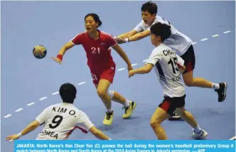  ?? — AFP ?? JAKARTA: North Korea’s Han Chun Yon (C) passes the ball during the women’s handball preliminar­y Group A match between North Korea and South Korea at the 2018 Asian Games in Jakarta yesterday.