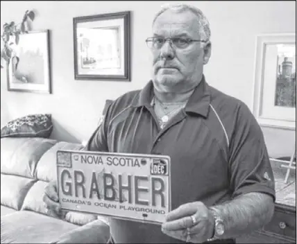  ?? FILE PHOTO ?? Lorne Grabher holds the licence plate that he is no longer allowed to have on his car because of the spelling of his last name.