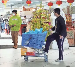  ?? MICHAEL CHOW/THE REPUBLIC ?? Shoppers protect themselves with masks while shopping at the Mekong grocery store in Mesa on March 17, 2020.