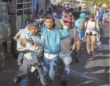  ??  ?? Migrantes salvadoreñ­os comenzaron ayer su viaje en caravana a EU, en San Salvador. En su mayoría huyen de la pobreza en América Central.