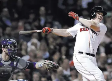  ?? Charles Krupa ?? The Associated Press Boston’s Brock Holt follows through on a pinch-hit, three-run home run in front of Blue Jays catcher Danny Jansen during the seventh inning of the Red Sox’s 7-2 victory Tuesday in Boston.