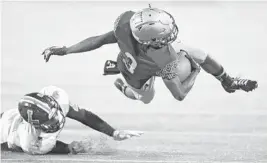  ?? MICHAEL LAUGHLIN/SUN SENTINEL PHOTOS ?? St. Thomas Aquinas receiver Jamal Cooney is tackled by Lakeland’s Quadir Hall during their 7A state championsh­ip game Friday night at Camping World Stadium in Orlando.