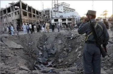  ?? RAHMAT GUL — ASSOCIATED PRESS ?? Security forces stand next to a crater created by massive explosion in front of the German Embassy in Kabul, Afghanista­n, Wednesday. The suicide truck bomb hit a highly secure diplomatic area of Kabul killing scores of people and wounding hundreds more.