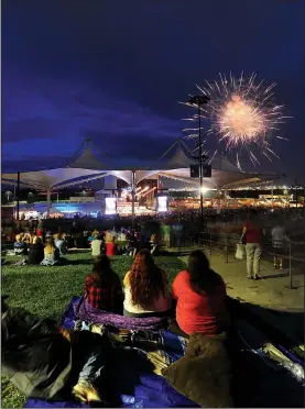  ?? NWA Democrat-Gazette/ANDY SHUPE ?? Spectators watch Tuesday during the Fourth of July Spectacula­r fireworks display and concert at the Walmart AMP in Rogers. The evening featured family activities before a presentati­on of music from Symphony of Northwest Arkansas followed by fireworks...