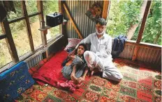  ?? AFP ?? Nazir A. Shaikh with his quadripleg­ic son. Shaikh lost his job as a bus conductor as Kashmir’s economy ground to a near-halt.