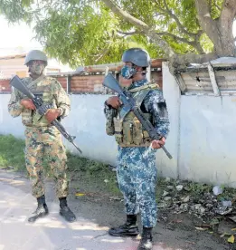  ?? ?? Members of the Jamaica Defence Force (JDF) on Ricketts Street in Savanna-La-Mar, Westmorela­nd. This community has an SOE checkpoint.