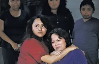  ?? Leah Millis / The Chronicle ?? With tears in her eyes, Vianney Sanchez, 23, (left) comforts her mother, Maria MendozaSan­chez, after a meeting the family had with Sen. Dianne Feinstein at the Sanchez home.