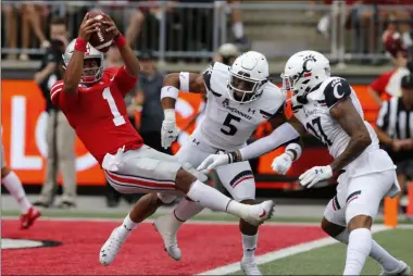  ?? JAY LAPRETE — THE ASSOCIATED PRESS ?? Ohio State quarterbac­k Justin Fields, left, dives over the goal line past Cincinnati defensive back Darrick Forrest, center, and linebacker Dorian Holloway during the first half Sept. 7 in Columbus.