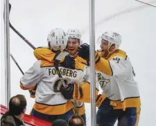  ?? ASSOCIATED PRESS ?? SCRATCHING ONE OUT: Filip Forsberg and the Predators celebrate his overtime goal last night in Chicago.