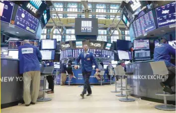  ?? — Reuters ?? Traders work on the floor of the New York Stock Exchange.