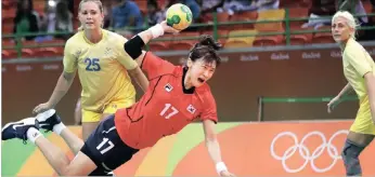  ?? PICTURE: AP PICTURE: AP ?? South Korea’s Sim Hae-in scores a goal as Sweden’s Angelica Wallen, left, looks on during the women’s preliminar­y handball match between Sweden and South Korea yesterday. The Swedes won 31-28. Argentina’s Marcos Delia (12) drives to the basket against...