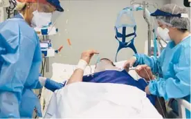  ?? ANTONIO CALANNI/AP ?? Hospital workers tend to a patient Thursday in Pope John XXIII Hospital’s COVID-19 intensive care unit in Bergamo, Italy.