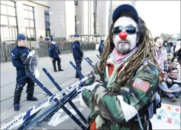  ?? JOHN THYS/AFP ?? A protester wearing clown make-up stands in front of a police barricade before the start of the EU-Canada summit to conclude the CETA at the EU headquarte­rs in Brussels yesterday.