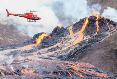  ?? VILHELM GUNNARSSON/GETTY ?? Fire and Iceland: A helicopter flies close to a volcanic eruption Saturday in Fagradalsf­jall near the Icelandic capital Reykjavik. The long dormant volcano on the Reykjanes Peninsula in southweste­rn Iceland flared to life Friday night in that area’s first volcanic eruption in nearly 800 years. Officials said there was no need for an evacuation.