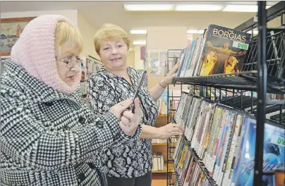  ?? SHARON MONTGOMERY-DUPE/CAPE BRETON POST ?? Diane Reid, left, of Donkin looks through DVDs at the Cape Breton Regional Library’s Glace Bay branch with assistance from manager Cindy Tiller. A total of 8,774 DVDs and 690 audio books were checked out at the Glace Bay branch last year.