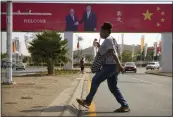  ?? THE ASSOCIATED PRESS ?? A woman crosses the street near a billboard commemorat­ing the state visit of Chinese President Xi Jinping in Port Moresby, Papua New Guinea, in 2018.