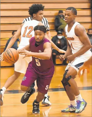  ?? ANDY LAVALLEY / POST-TRIBUNE PHOTOS ?? Hammond’s Reggie Abram, center, gets past West Side’s Nisaih King, left, and Quimari Peterson and heads to the basket during their game in Gary on Friday.