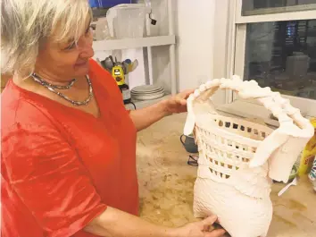  ?? Christina Hennessy / Hearst Connecticu­t Media ?? Ceramicist Alison Palmer shows off one of her new works in her studio. This work, and others, are expected to be on display at the Sharon Historical Society and Museum from Sept. 8 to Oct. 19.