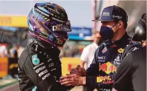  ?? AFP PIC ?? Mercedes-AMG Petronas driver Lewis Hamilton (left) and Red Bull’s Max Verstappen shake hands after the sprint qualifying session of the British Grand Prix on Friday.