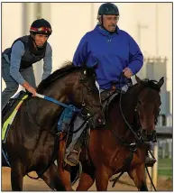  ?? (AP/Charlie Riedel) ?? Trainer Steve Asmussen (right) leads Arkansas Derby winner and Kentucky Derby hopeful Super Stock onto the track this week at Churchill Downs in Louisville, Ky.