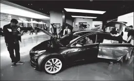  ?? TRIBUNE NEWS SERVICE ?? People browse the Model 3 at the Tesla showroom at the Westfield in Century City.