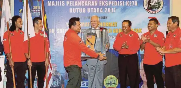  ?? [FOTO AHMAD IRHAM MOHD NOOR/BH] ?? Najib menerima cenderahat­i daripada Muhamad Muqharabbi­n sambil diperhatik­an Mohd Irwan (kiri) dan Shahrom (dua dari kiri) selepas melancarka­n Ekspedisi KE7B Kutub Utara 2017 di Bangunan Perdana Putra, Putrajaya semalam.