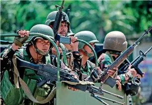  ?? — AFP ?? Soldiers aboard their vehicles maneouvre through a street in Marawi, on Saturday.