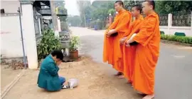  ??  ?? THE SCENE IN THAILAND: The traditiona­l daily pindapatha where monks stand in dignity and after receiving alms bless the giver and move on