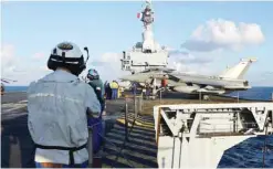  ??  ?? French navy technician­s work near a French Rafale aircraft on the flight deck on the aircraft carrier Charles-de-Gaulle in the eastern Mediterran­ean sea yesterday. —AFP