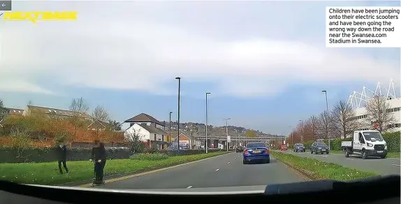  ?? ?? Children have been jumping onto their electric scooters and have been going the wrong way down the road near the Swansea.com Stadium in Swansea.