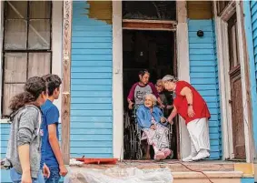  ?? Kaylee Greenlee Beal / Contributo­r ?? Josie Trevino, 95, emerges from her Dignowity Hill home Saturday with the assistance of three of her daughters to see the improvemen­ts made to the house by volunteers organized by the city’s Office of Historic Preservati­on.