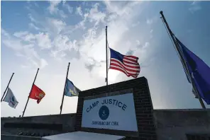  ?? The Associated Press ?? In this photo reviewed by U.S. military officials, flags fly at half-staff at Camp Justice on Aug. 29, 2021, in Guantanamo Bay Naval Base, Cuba. Majid Khan, the onetime courier for al-qaida is a free man after serving more than 16 years at Guantanamo, and surviving torture at notorious CIA “black sites.” Khan is now in Belize, after that nation reached agreement with the Biden administra­tion to take him.