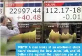  ?? —AP ?? TOKYO: A man looks at an electronic stock board showing the Dow Jones, left, and US dollar rate against the Japanese yen at a securities firm in Tokyo yesterday.