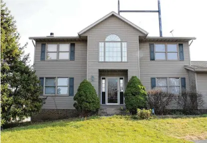  ?? CONTRIBUTE­D PHOTOS ?? The front of the vinylsided, twostory home features a concrete walk, covered entry and storm door covering the front door. There are double sidelights flanking the front door.