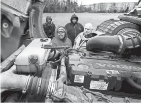  ?? COMMERCIAL APPEAL ?? Student Latrice Mason, front left, runs through a commercial truck pre-check with CDL Instructor Bill Phillips, right, and fellow students Konuz Ahmed, back left, and Robert Miller, back right, during a class Friday afternoon. Olympic Career Training Institute recently began providing Commercial Driver and License Training and hopes to train 500 Shelby County drivers over the next year, helping combat the national truck driver shortage. MARK WEBER / THE