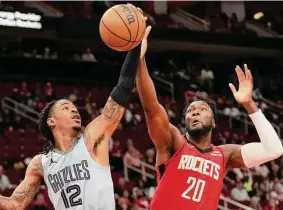  ?? Yi-Chin Lee/Staff photograph­er ?? Rockets center Bruno Fernando tries to defend Grizzlies star Ja Morant on a night when the Memphis guard went off for 49 points in a win over Houston.