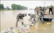  ?? WASEEM ANDRABI/HT ?? Workers place sandbags along the banks of the Jhelum at Kursoo Rajbagh area of Srinagar on Saturday.